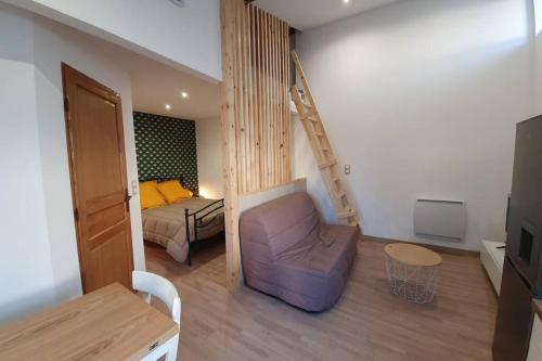 una sala de estar con una cama y una escalera en una habitación en PETIT COCON en Boisset-Saint-Priest