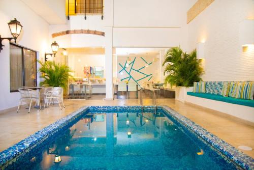 a swimming pool in a living room with a table at Hotel Virrey Cartagena in Cartagena de Indias