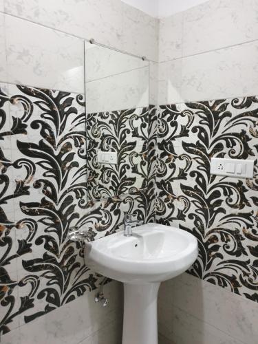 a bathroom with a sink and a black and white wallpaper at Hotel The Ganga Castle in Haridwār