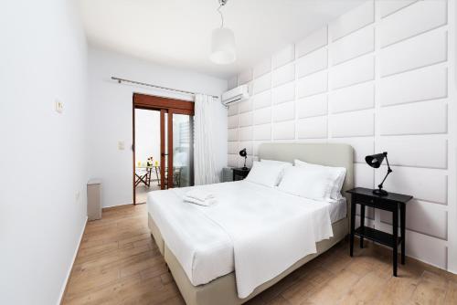 ロードス・タウンにあるRitas Modern In-City Houseの白いベッドルーム(ベッド1台、テーブル付)