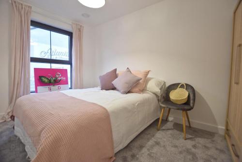 um quarto com uma cama com uma janela e uma cadeira em Coastal Links em Portrush