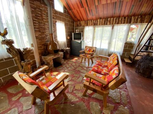 a living room with two chairs and a tv at Cabañas Los Abuelos in Zacatlán