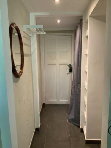 un couloir avec une porte blanche et un miroir dans l'établissement Centre Historique de Fréjus - face à la mairie, à Fréjus