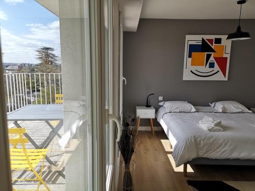 une chambre avec un lit et un balcon avec une table dans l'établissement Appartement tout confort 2 chbres - 72m2 - avec terrasse et vue Pyrénées, à Pau