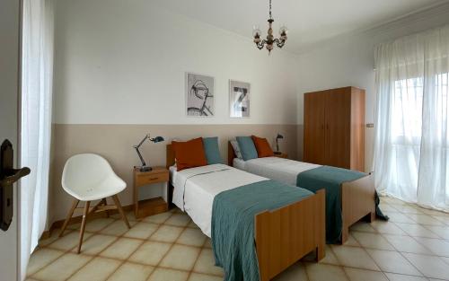 sypialnia z 2 łóżkami, biurkiem i krzesłem w obiekcie A&B Homes Leuca w mieście Leuca