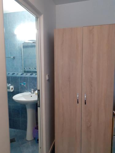 a bathroom with a sink and a wooden cabinet at Casa Azugeana in Azuga
