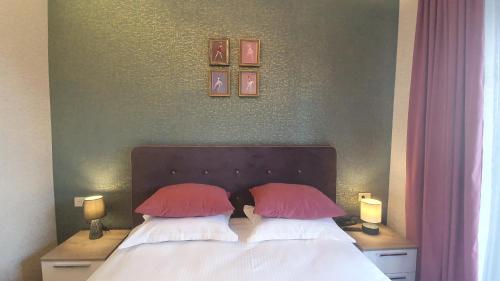 a bedroom with a bed with two red pillows at JINJOTEL Gyumri in Gyumri
