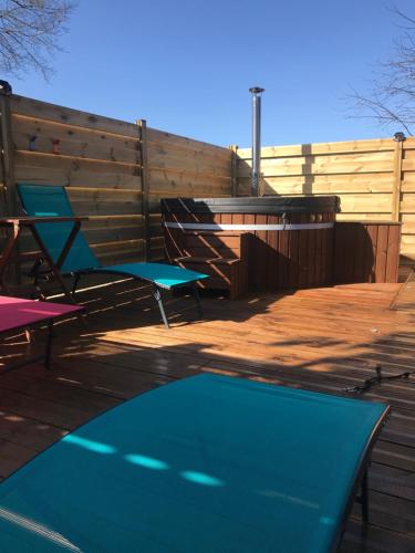 a deck with two chairs and a swimming pool at Le Breil Furet in Ménéac