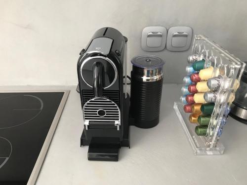 a black iron sitting on a counter next to a cup at Elisa Seaside Luxury Suite in Loutraki
