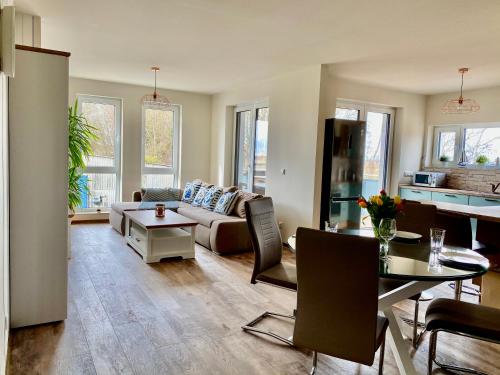 uma sala de estar com um sofá e uma mesa em Haus Meerruhe Karlshagen Apartment 1-6 em Ostseebad Karlshagen