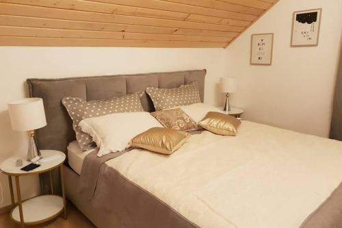 a bedroom with a large bed with gold and white pillows at Villa Lady Di Plitvice in Vrhovine