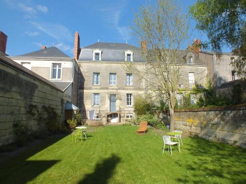 un patio con sillas y un gran edificio en A la Fleur de Lys, en Langeais