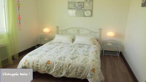 sypialnia z łóżkiem z białą kołdrą i 2 lampami w obiekcie Gîte L'échappée Belle ! w mieście Saint-Aignan