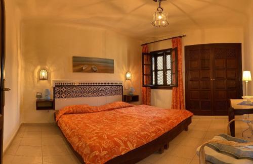 Playa del AguilaにあるApartment Del Marのベッドルーム1室(大型ベッド1台、オレンジ色のベッドカバー付)