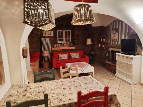 a living room with a table and a red couch at Appartamento Sopramonte in Trento