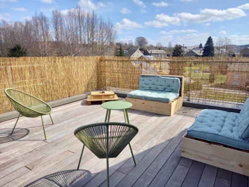a patio with chairs and a couch and a table at Le grenier de Charlotte in Libin