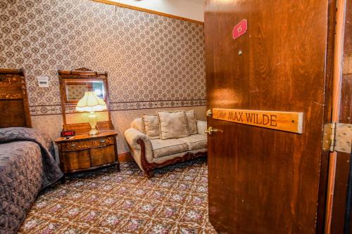 a bedroom with a bed and a chair and a mirror at Irma Hotel in Cody