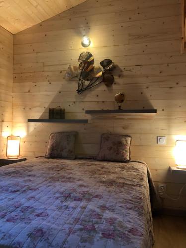 1 dormitorio con 1 cama en una pared de madera en Fanjeaux Aude Le Chalet, en Fanjeaux