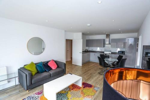 a living room with a couch and a kitchen at EXQUISITE ONE BED APARTMENT in Woolwich