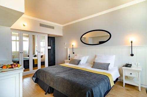 a hotel room with a large bed and a mirror at Royal Plaza Hotel in Tiberias