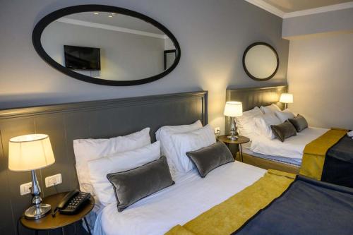 a hotel room with two beds and a mirror at Royal Plaza Hotel in Tiberias