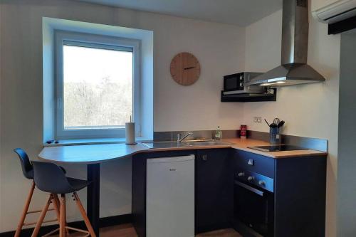 eine Küche mit einer Theke, einem Waschbecken und einem Fenster in der Unterkunft Studio avec vue sur la vezere in Uzerche