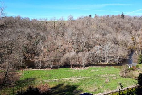 Blick auf ein Feld mit Bäumen und eine Straße in der Unterkunft Studio avec vue sur la vezere in Uzerche