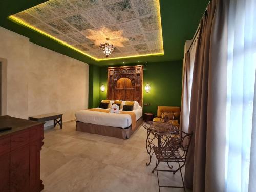 a bedroom with a bed and a green wall at Murallas de Jayrán Hotel Boutique in Almería
