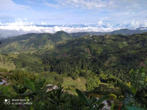 a view of a mountain range with clouds in the background at Mirador Finca Morrogacho in Manizales