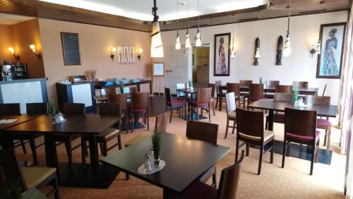 una sala da pranzo vuota con tavoli e sedie di ParkHotel Nieheim a Nieheim