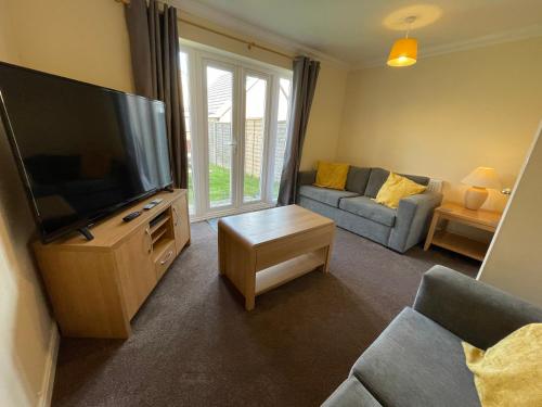a living room with a large flat screen tv at St Margarets House - Modern - 3 Bed Townhouse - Parking - Marvello Properties in Norwich