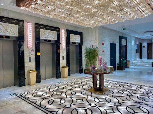 a lobby with a table in the middle of a room at Violet Al Shisha Hotel in Makkah