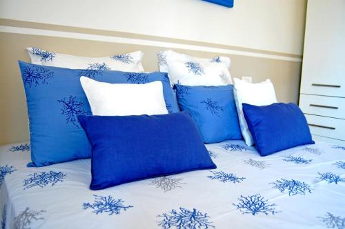 a bed with blue and white pillows on it at SeaBaudia 2 SENZA TERRAZZA in Sabaudia
