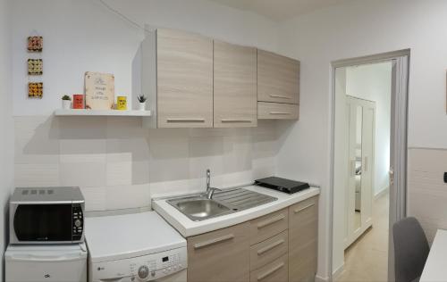 a small kitchen with a sink and a microwave at House del Levante in Bari
