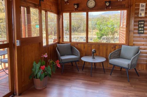 a room with two chairs and a table and a clock at Villarreal Lodge Hotel Ecológico in Totolapan