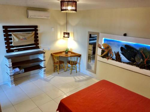 a room with a living room with a fish tank on the wall at Pousada Parracho in Maracajaú