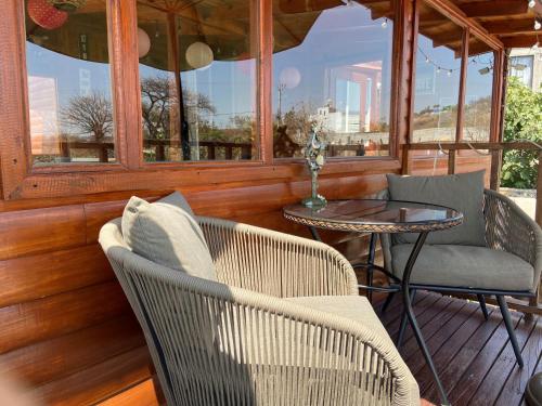 a porch with two chairs and a table and a window at Villarreal Lodge Hotel Ecológico in Totolapan