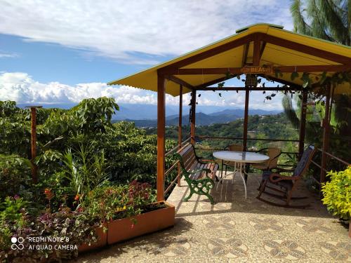 a patio with a table and chairs under a canopy at Mirador Finca Morrogacho in Manizales