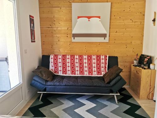 a blue couch in a room with a bed at Appartement d'une chambre avec balcon a Cauterets in Cauterets