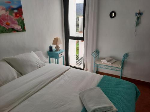 Un dormitorio con una gran cama blanca y una ventana en AIRUNNES Atico duplex Zahara primera linea en Zahara de los Atunes