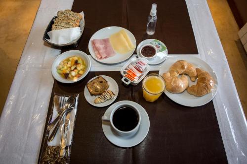 a table topped with plates of food and a cup of coffee at Las Marías Hotel Boutique in Tilcara