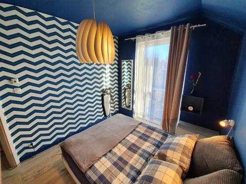 a bedroom with a bed with a checkered blanket at Azyl Puck in Puck