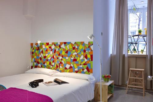 een slaapkamer met een bed met een kleurrijk hoofdeinde bij Pil Pil Hostel Bilbao in Bilbao