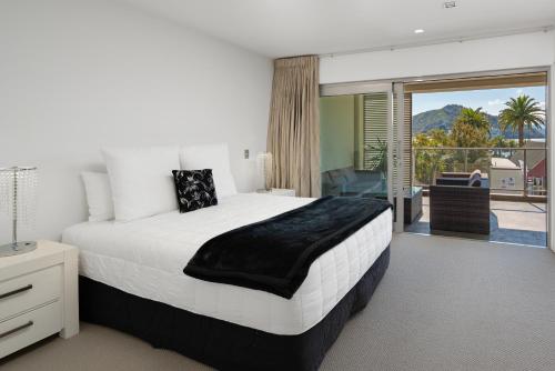 a bedroom with a large bed and a balcony at Luxury Waterfront Apartment - Abode No 1 in Picton