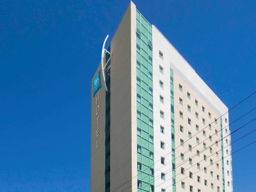 a large building with a clock on top at ibis budget Vitoria in Vitória