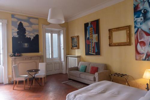 a bedroom with a bed and a couch and a chair at Art Gallery Suite in Bergamo