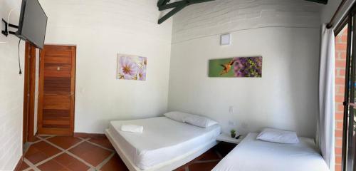 a room with two beds and a tv in it at La Manola Finca Hotel in Doradal