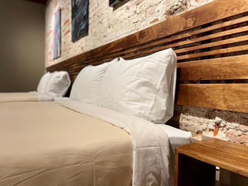 a bedroom with a white bed with a wooden wall at Hotel Casa Azabache in San Cristóbal de Las Casas