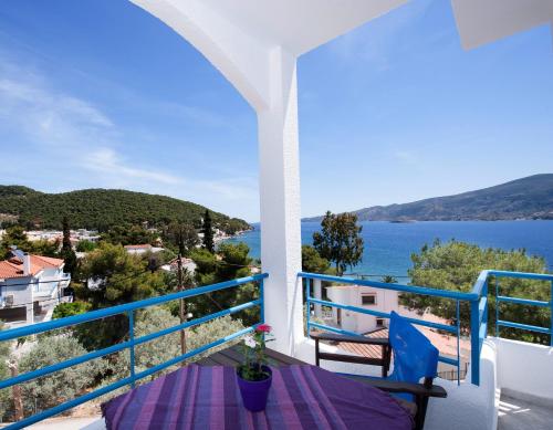 a balcony with a table and a view of the water at Christine Studios in Poros