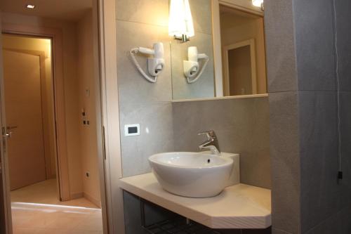 a bathroom with a white sink and a mirror at La Casa di Gino in San Nicola